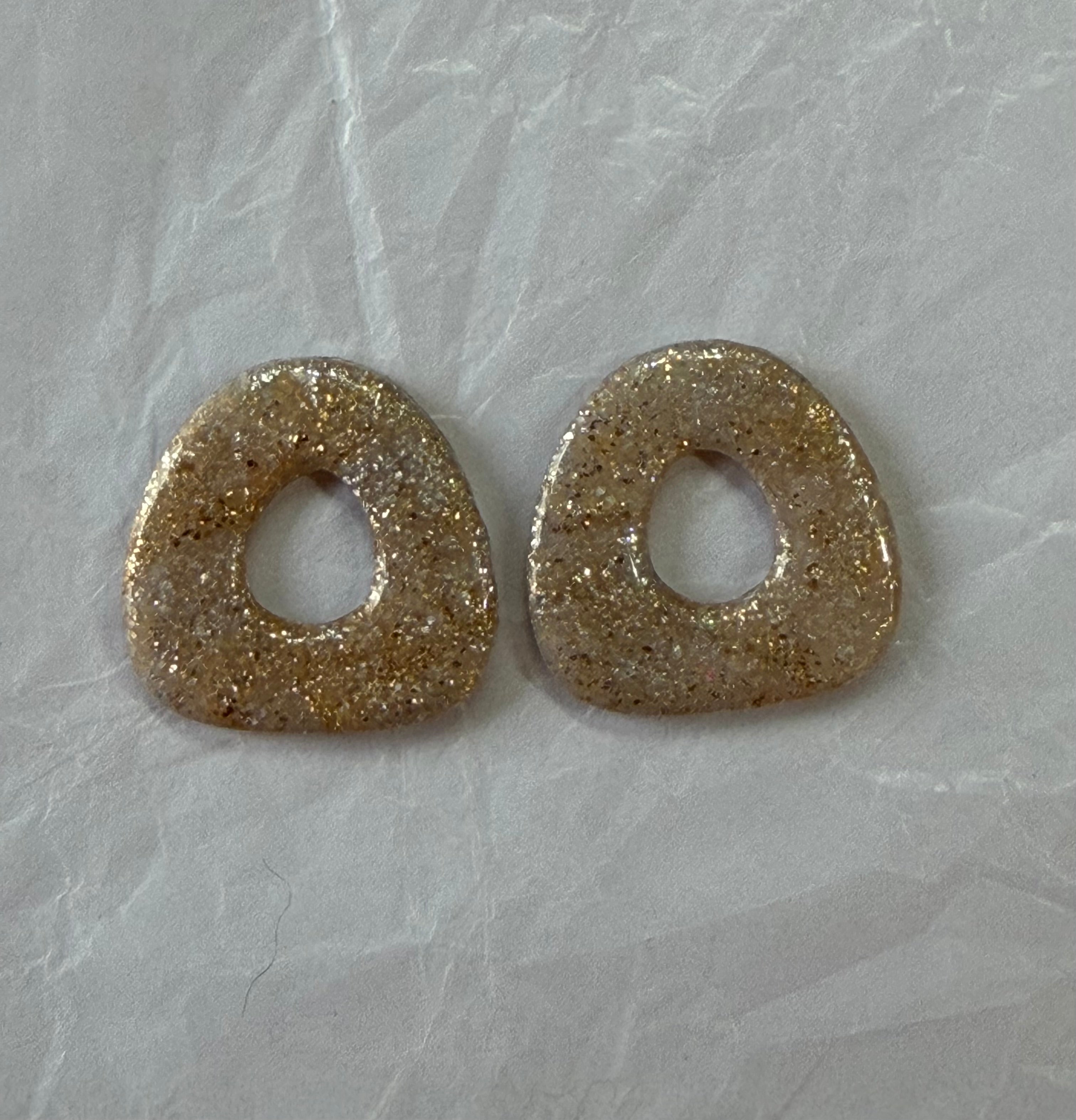 Boucles d'oreilles artisanales en pâte polymère — légères, organiques et lumineuses.

Confectionnées à la main avec des paillettes champagne et une touche bohème naturelle, elles apportent une brillance douce et une élégance décontractée.