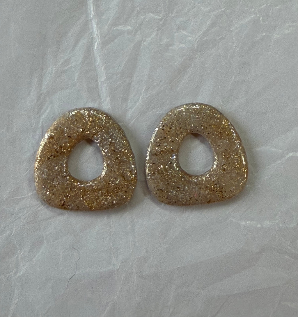 Boucles d'oreilles artisanales en pâte polymère — légères, organiques et lumineuses.

Confectionnées à la main avec des paillettes champagne et une touche bohème naturelle, elles apportent une brillance douce et une élégance décontractée.