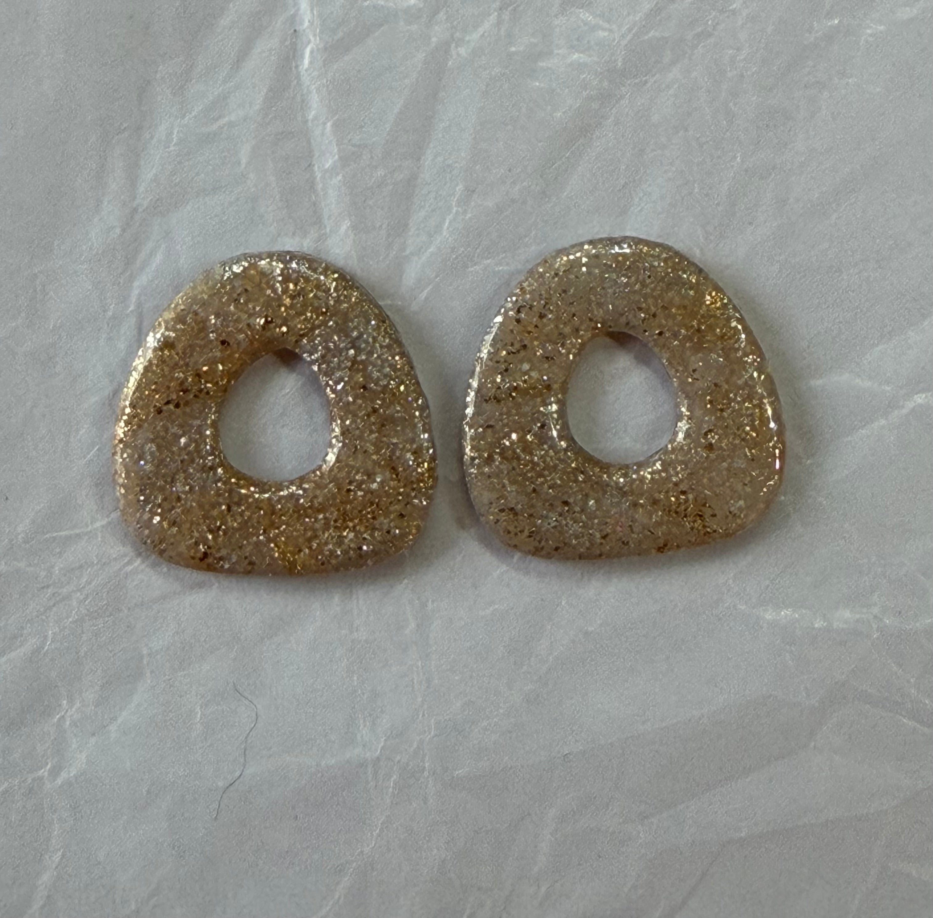 Boucles d'oreilles artisanales en pâte polymère — légères, organiques et lumineuses.

Confectionnées à la main avec des paillettes champagne et une touche bohème naturelle, elles apportent une brillance douce et une élégance décontractée.